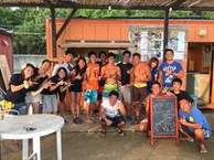 海の家の前で大人数がポーズを取りながら並んでいる写真