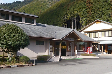 山の前に建つグレーの屋根をした建物入り口の写真