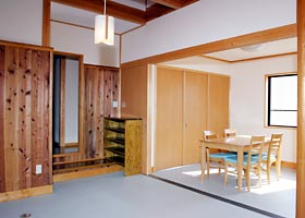 木造の机や椅子に箪笥が設置されている部屋の写真