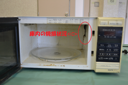 電子レンジ庫内の焼損部分(右上角)が赤丸で囲まれた電子レンジの写真