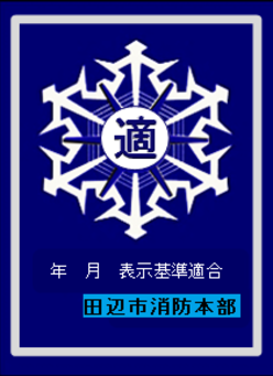 雪の結晶のような白いマークの中央に「適」の文字が入り、下部に「表示基準適合 田辺市消防本部」と記された青地の表示マークの写真