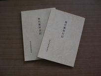 黒い背景の中に置かれている二冊の冊子の写真