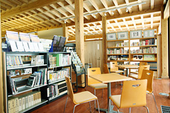 多くの書籍を保存している本棚や休憩や勉強ができる椅子や机が置かれている場所の全体の写真