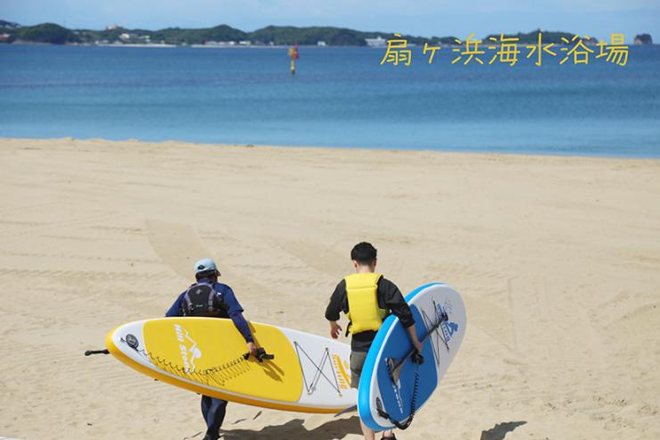 扇ヶ浜海水浴場でSUPボードを抱えて歩く2人