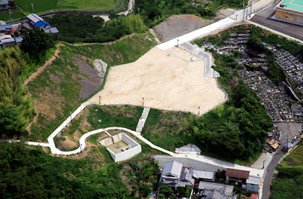 住宅地の傍に広がる砂地の土地を上空から撮影した写真