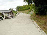 奥に向かって坂になっている道幅の広い道路の写真