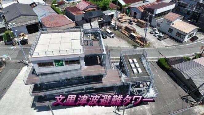 「文里津波避難タワー」と書かれ、住宅地の前に建てられた4階建ての津波避難タワーの写真（YouTubeへリンク）