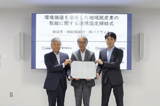 3人並んび協定書を掲げ環境価値を活用した地域脱炭素の取組に関する連携協定を締結した際の写真