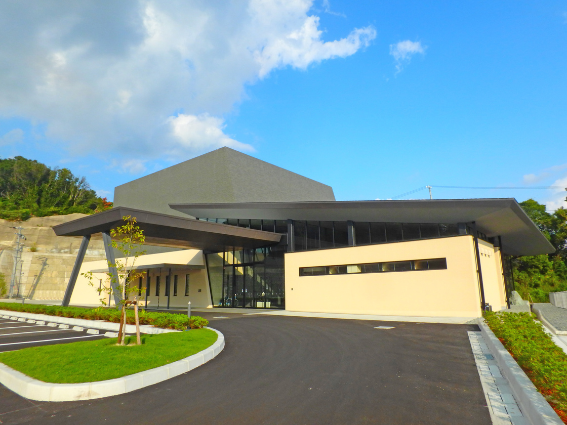 ベージュの壁面と黒い屋根が対照的な、平屋建ての田辺市斎場の外観写真