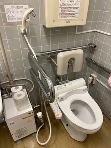 多目的トイレの設備の便器に洗浄用の水栓やシャワーが設置されたタイプの写真