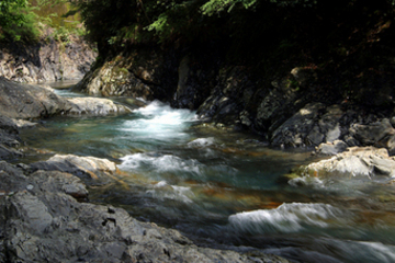 荒々しい岩肌の間を流れている川の写真