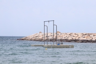 防波堤を背に海の上にターザンロープが浮かんでいる写真