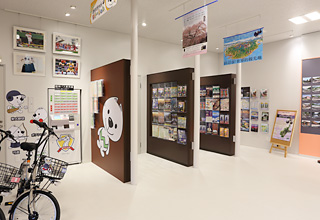 壁にパンフレット棚が設置されて沢山のパンフレットが置かれているコーナーの写真