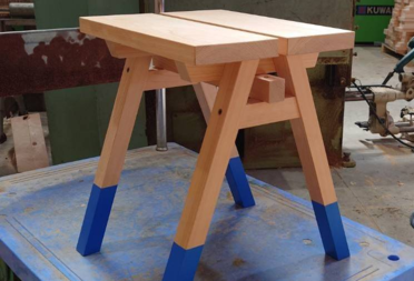 脚の先が青くなっている背もたれがない木の椅子の写真