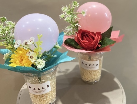 紫の風船が付いた花束と赤の風船が付いた花束の写真