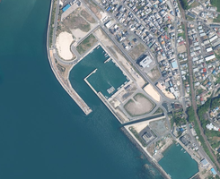 防波堤と港湾施設が整備された海沿いの街並みを俯瞰した写真