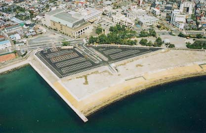 海沿いに造成された大型駐車場と市街地の様子を俯瞰した写真