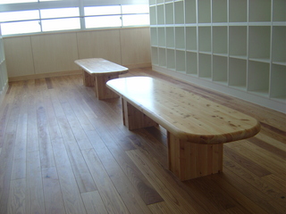 部屋の中央に楕円形の木造ベンチが2つ並んだ写真