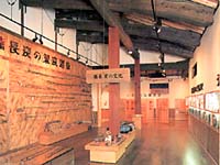 木張りの壁に複数展示された棒状の木の写真