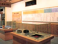 ガラスケースに収められた昔の道具や、壁に貼られた年表などの展示品の写真