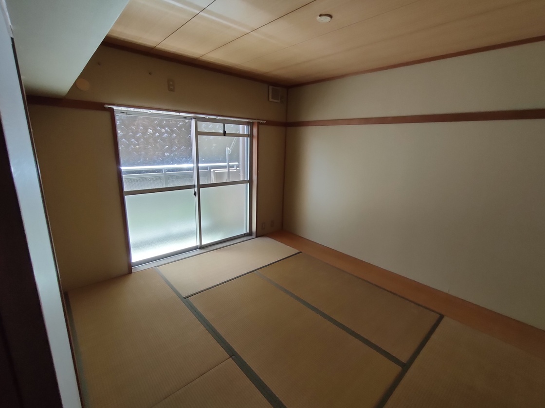 バルコニーに続く大きな窓のある畳6畳が敷かれた和室の写真