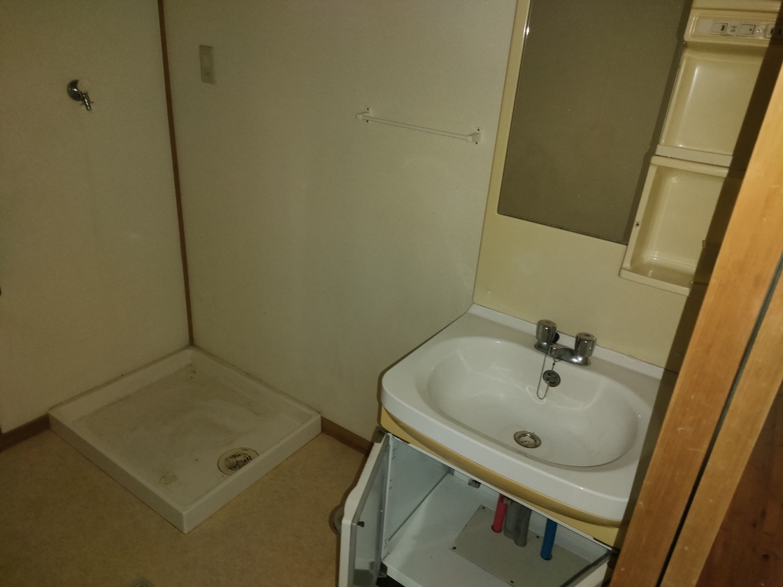 洗濯機の設置スペースや鏡の備え付けられた洗面台がある洗面所の写真