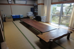 長いテーブルが組み合わせて置かれている畳の床の和室の写真