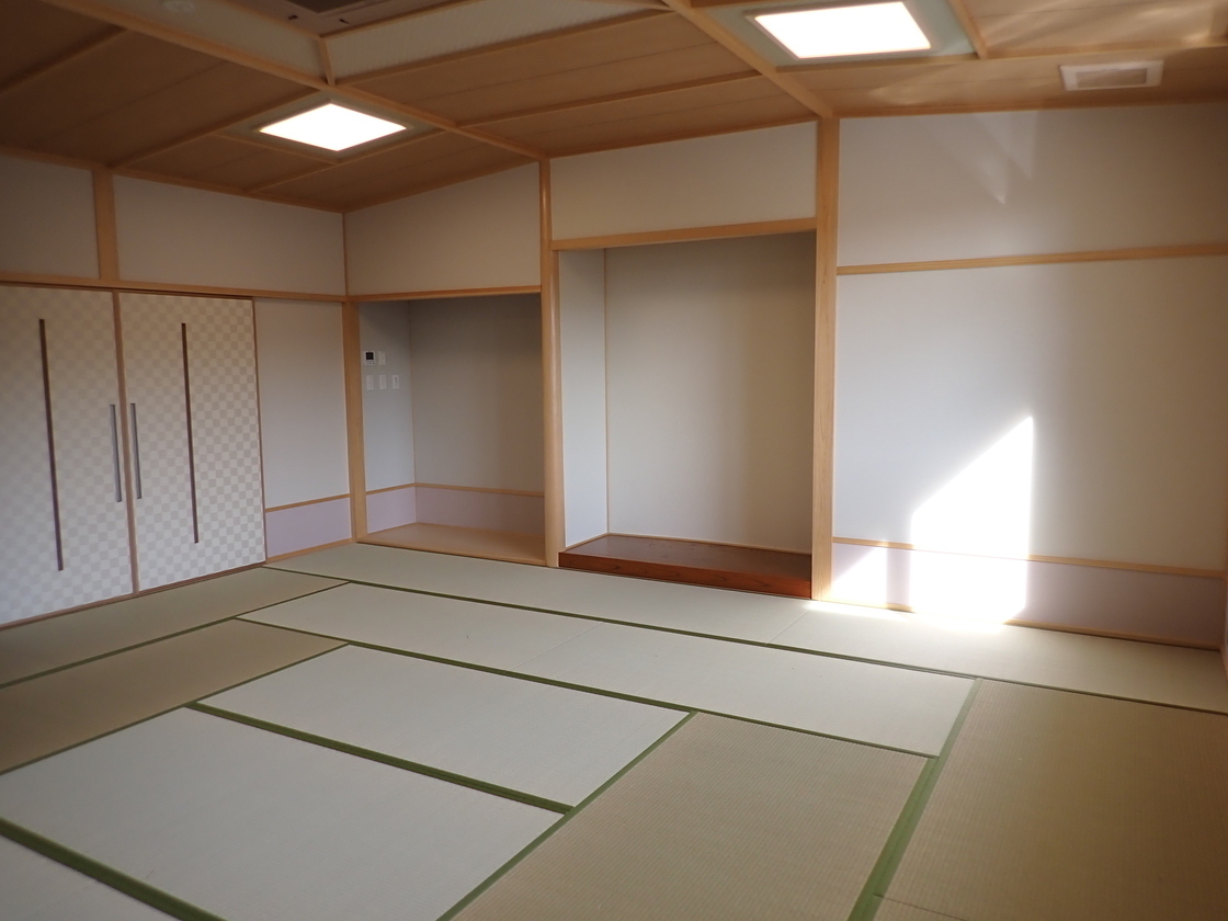 窓から日が差している畳の床をした和室の写真