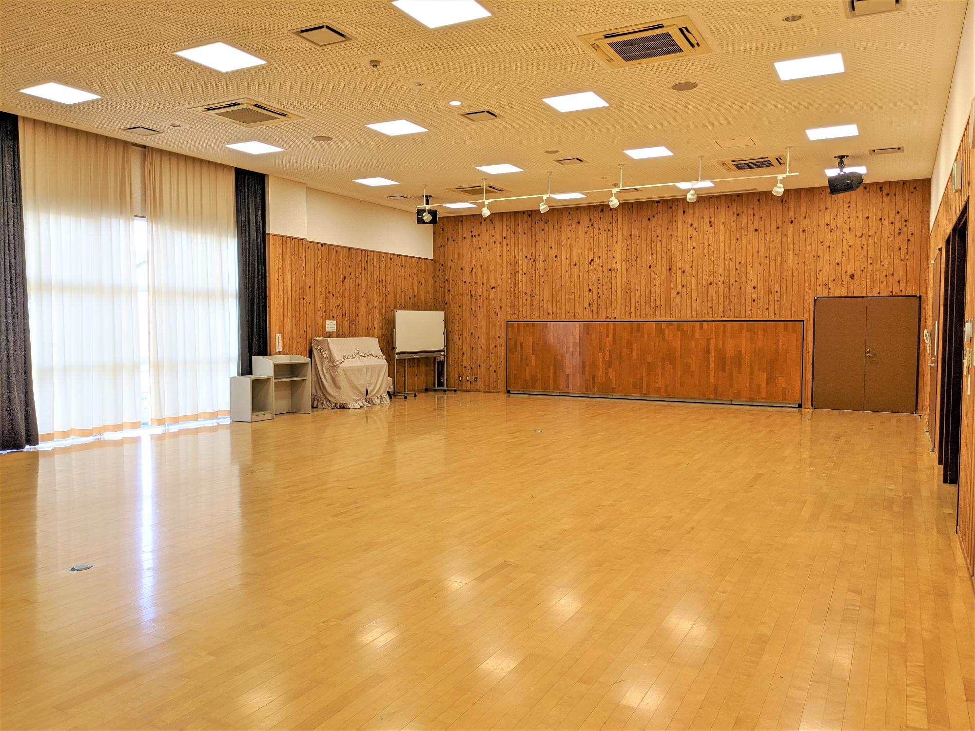 フローリングの床に木製の壁の広い室内の写真