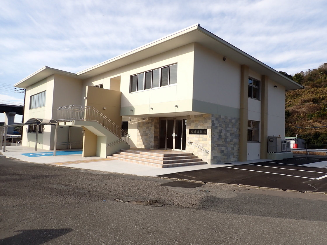 入口に階段がついている白い外装をした建物の写真