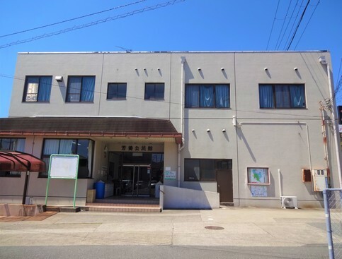 入り口に庇がある四角い建物の外観の写真