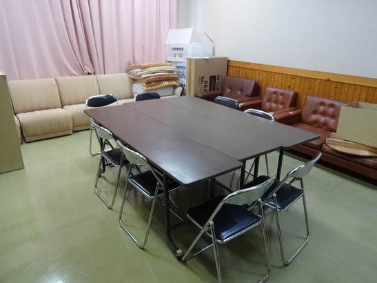 中央にテーブルとイスがあり隅にソファーが複数設置されている部屋の写真