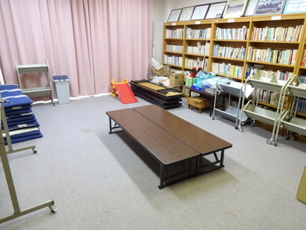 中央に脚の低いテーブルが置かれており端に本棚が並んでいる部屋の写真