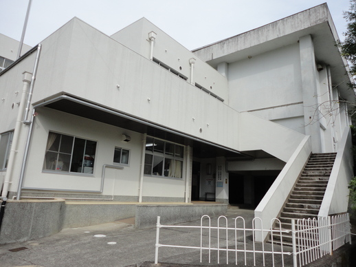 二階まで続く階段が外に備えられている建物の外観の写真