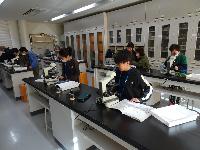 発明クラブ第７回講座、光学顕微鏡でミジンコの観察を行うクラブ員たちの写真