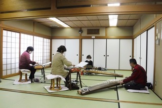 和室で楽器を扱う4人の写真