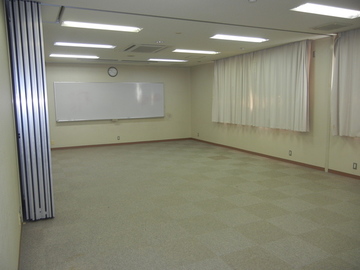 壁にホワイトボードが備えられた会議室の写真