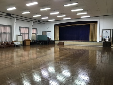 奥に舞台のある広いスペースのホールの写真