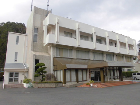 白い外壁をした3階建ての建物の写真