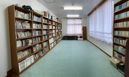 壁際に設置された複数の本棚に本が収納されている部屋の写真