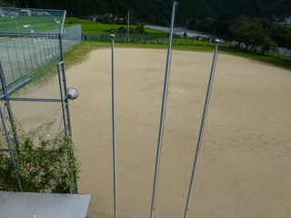 地面に鉄の棒が3本刺さっている屋外グラウンドの写真