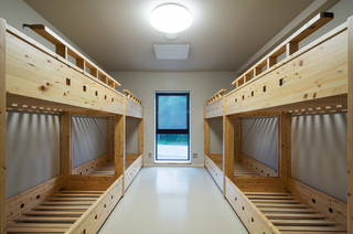 部屋の両側に2段ベッドが2つずつ置かれている写真