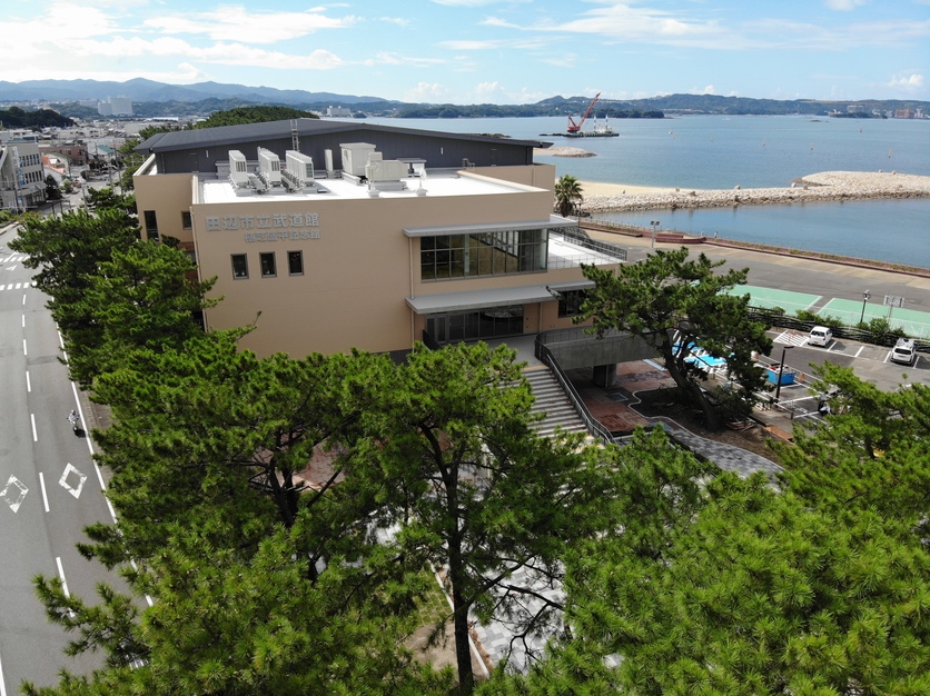 田辺市立武道館と書かれている薄茶色をした建物の写真