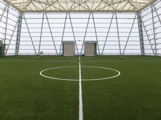 壁と天井の骨組みが剥き出しになっている芝の室内フットサルコートの写真