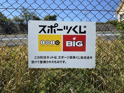 金網に貼られたスポーツくじ支援のお知らせの写真