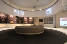 映像が映る円形の壁の部屋に大きな丸いソファが置かれている写真