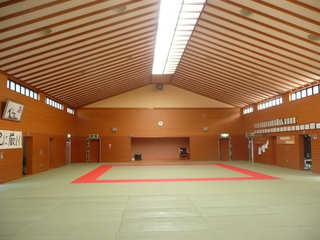 左右の小窓と三角屋根の天井から光が差し込む道場の写真