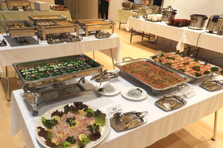 白いテーブルクロスが敷かれたテーブルに沢山の食材がバイキング形式で用意されている写真