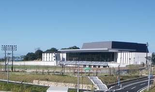 青空の下道路沿いにある大規模施設の外観写真