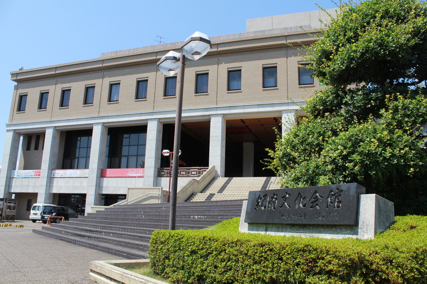 「紀南文化会館」と書かれた館銘板の奥に建つ茶色の建物の写真